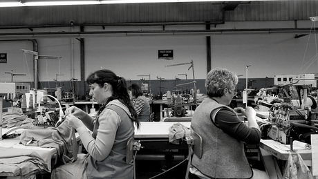 2 women working at sewing machines provides the backdrop of an article by hernest project about transparency in sustainable fashion. 