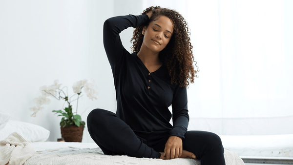 Model wearing black henley long sleeve sweatshirt made from sustainable Tencel fabric