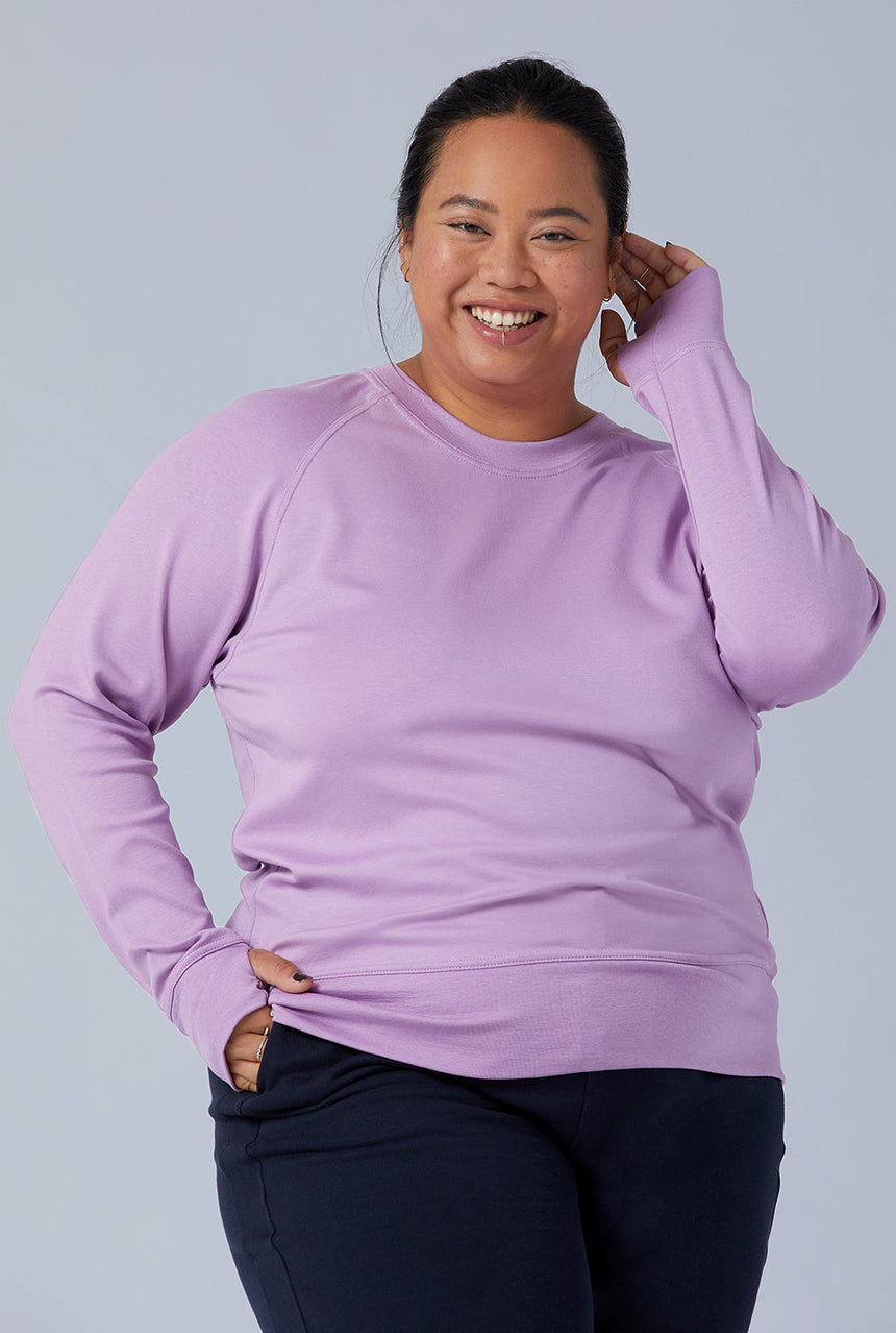 Woman wearing loungewear crewneck sweatshirt made from sustainable TENCEL and organic cotton in lilac 1