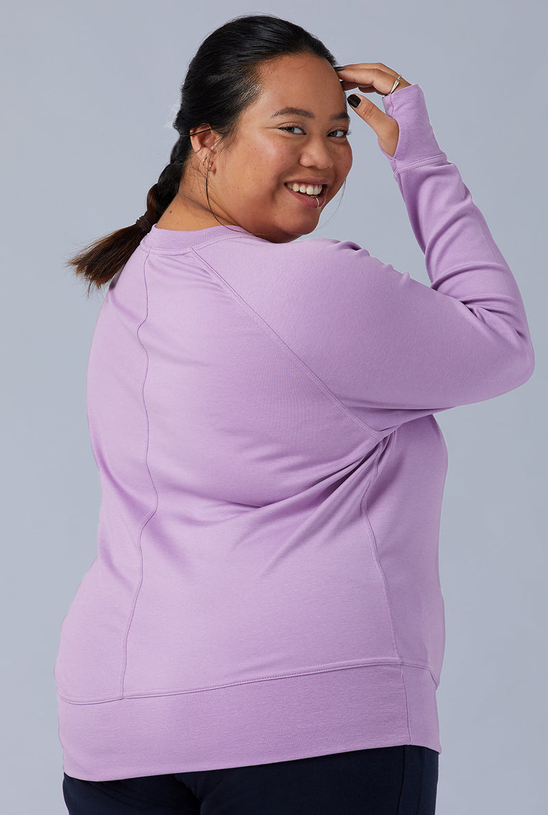 Woman wearing loungewear crewneck sweatshirt made from sustainable TENCEL and organic cotton in lilac 2