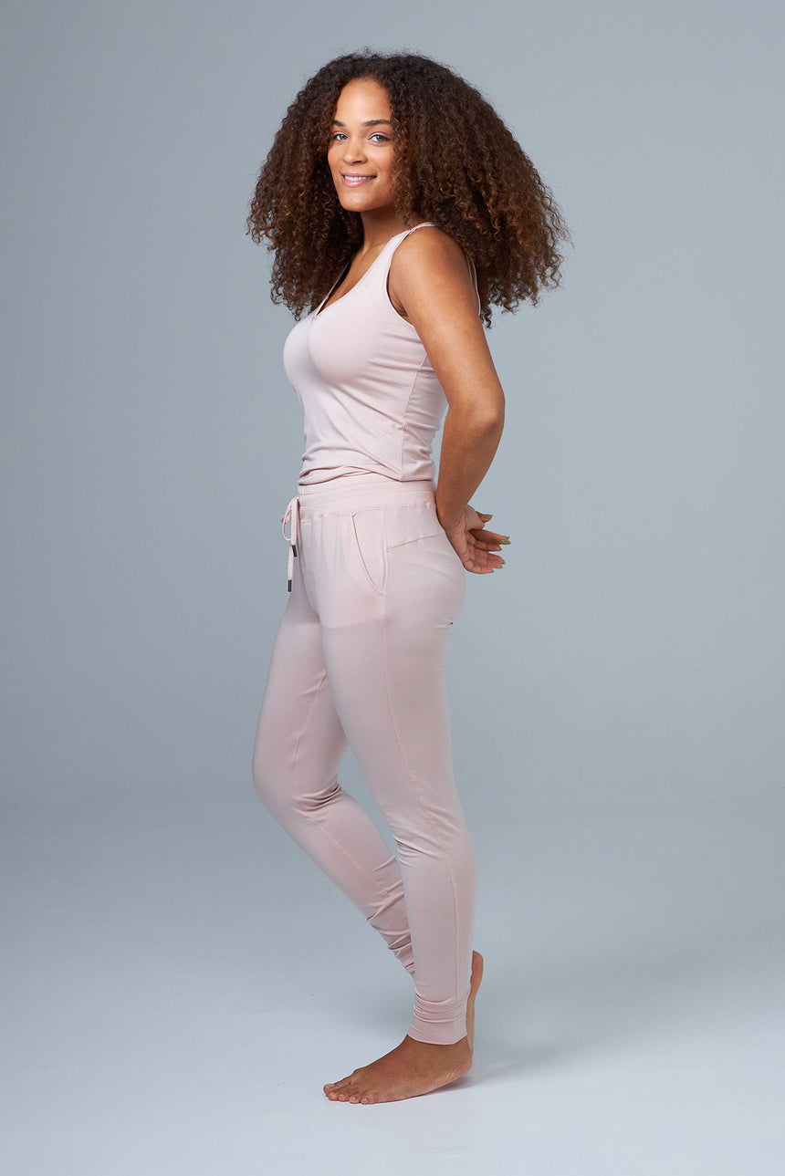 woman wearing pink lounge pants and pink tank top side view