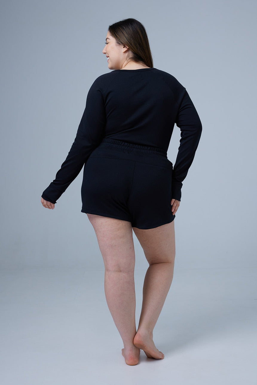 woman wearing black tencel cotton lounge shorts and black tshirt back view