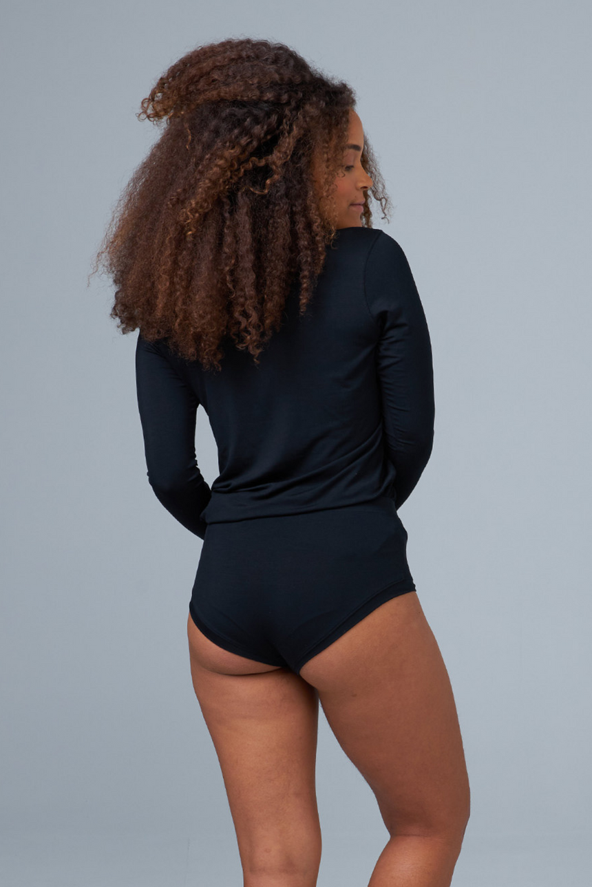 woman wearing black sleep shorts and black sleep top back view