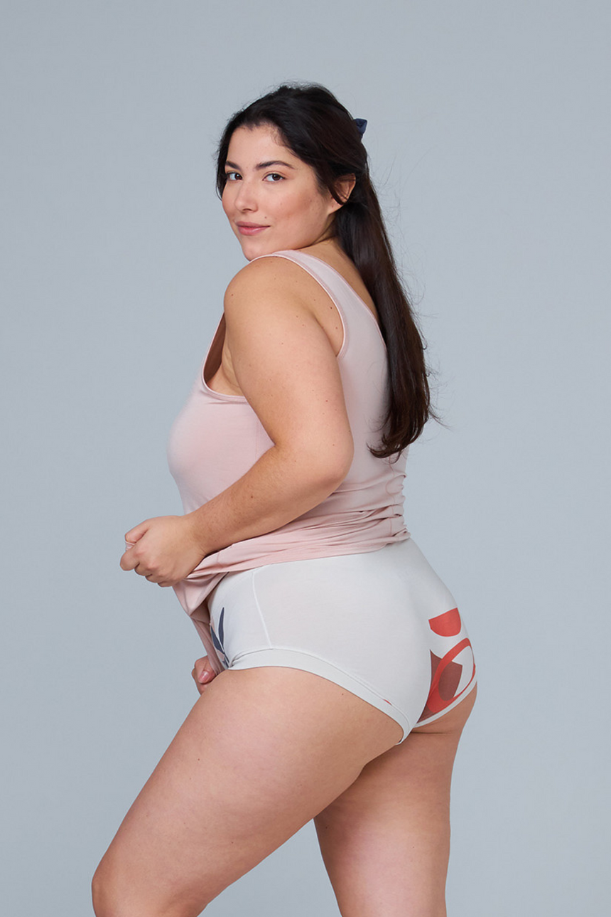 woman wearing multicolor sleep shorts and pink tank top back view
