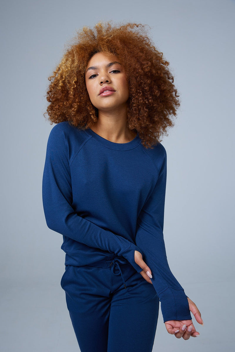 Woman wearing loungewear crewneck sweatshirt made from sustainable TENCEL and organic cotton in blue 1