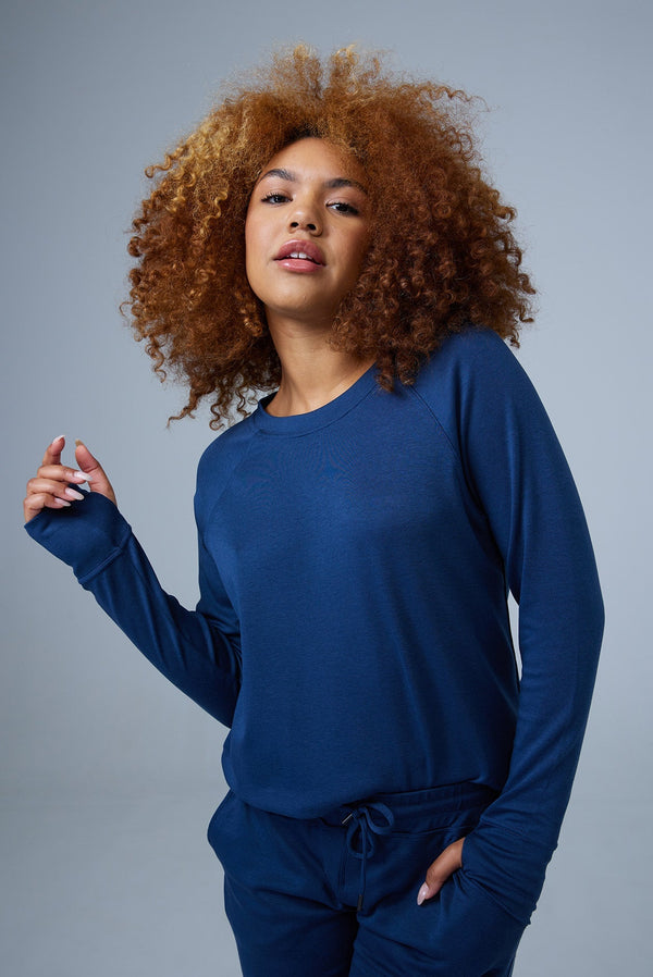Woman wearing loungewear crewneck sweatshirt made from sustainable TENCEL and organic cotton in blue 2