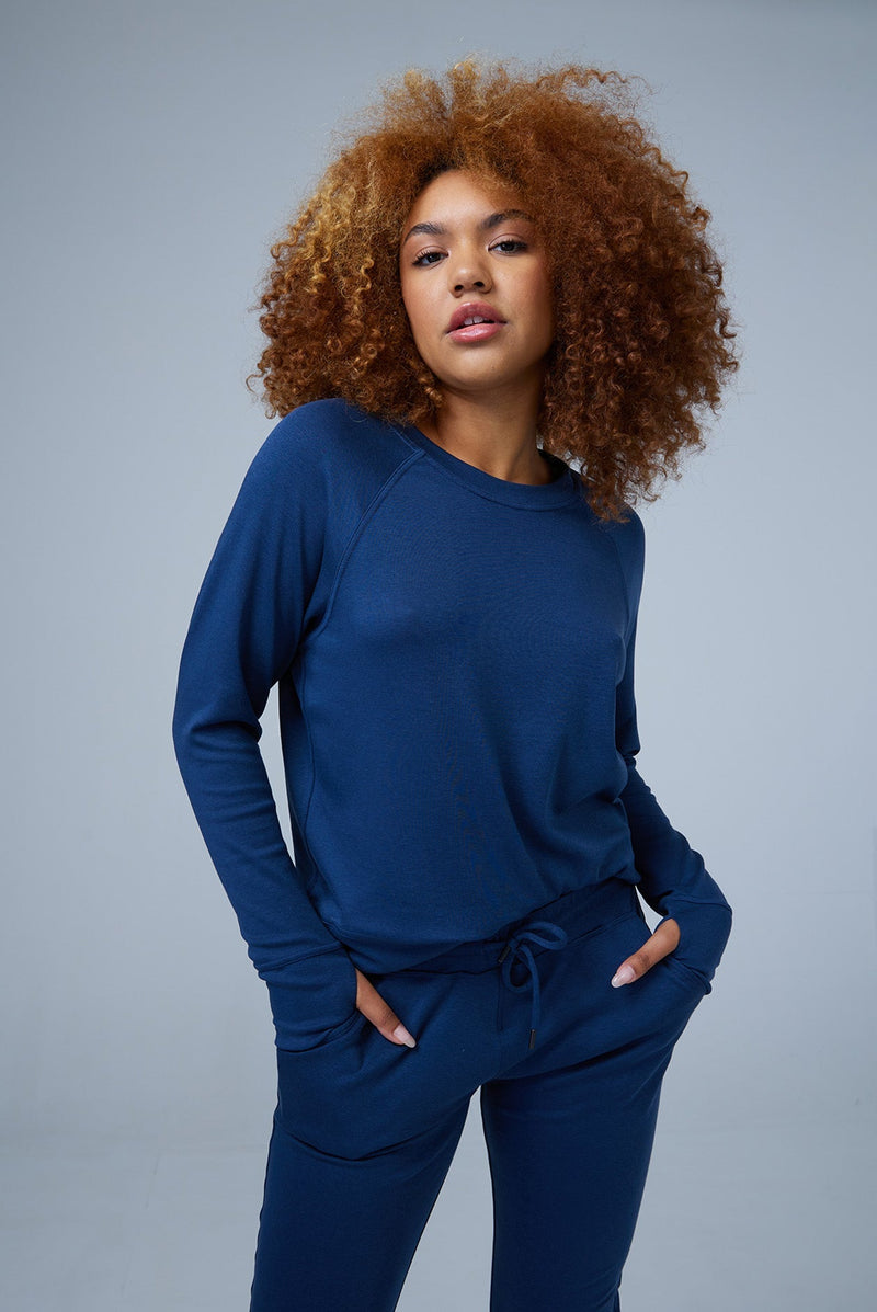 Woman wearing loungewear crewneck sweatshirt made from sustainable TENCEL and organic cotton in blue 3