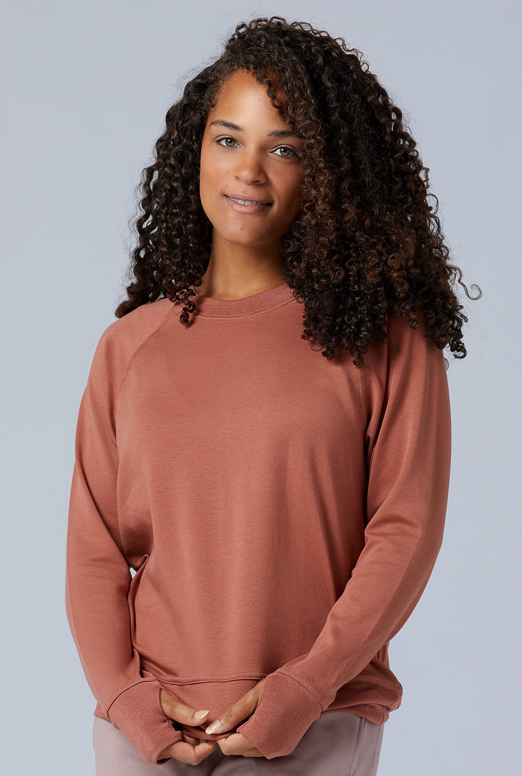 Woman wearing loungewear crewneck sweatshirt made from sustainable TENCEL and organic cotton in copper brown 1