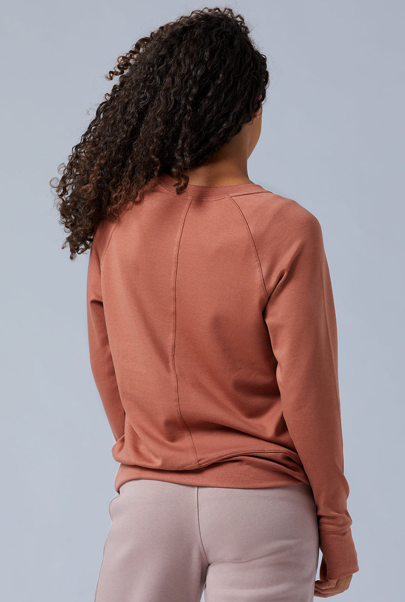 Woman wearing loungewear crewneck sweatshirt made from sustainable TENCEL and organic cotton in copper brown 2